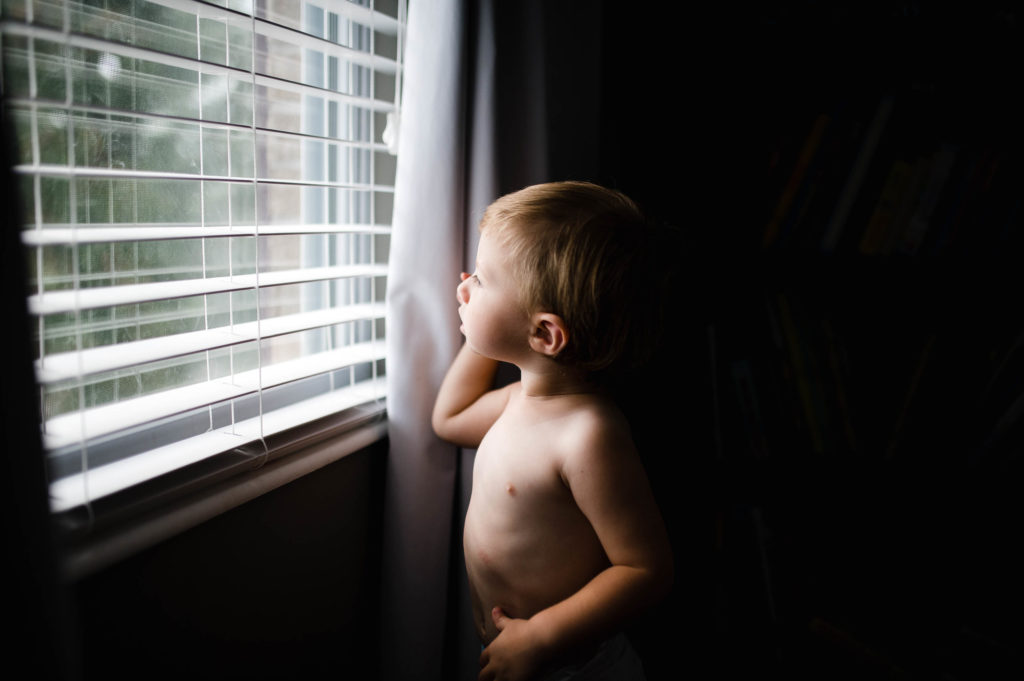 moody window portrait of toddler