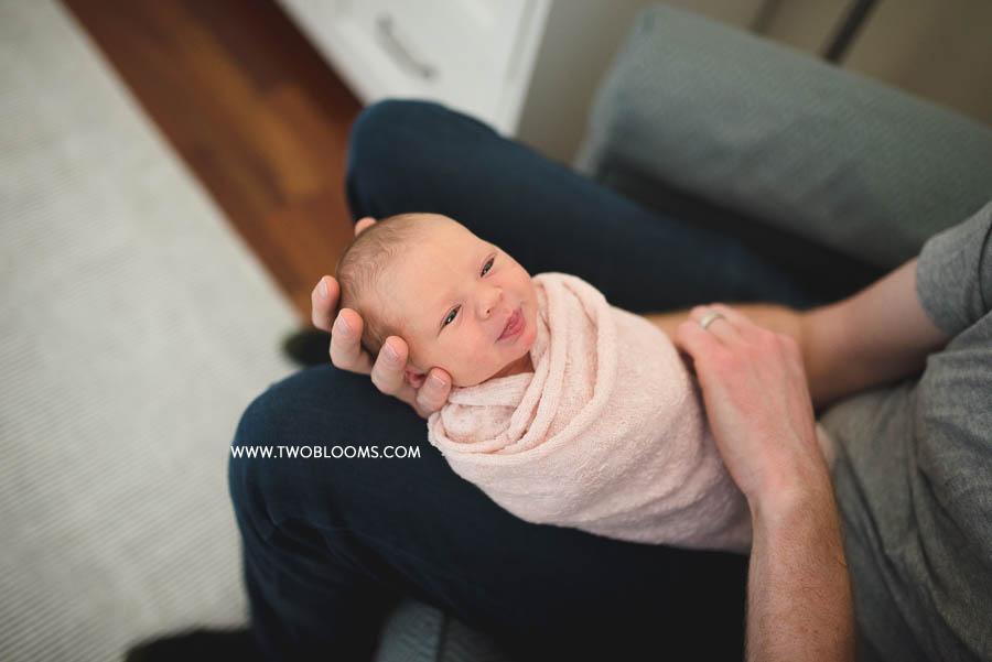 lifestyle newborn baby in dad's arms